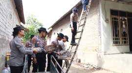 Personil polres Kediri membantu pasang genting warga terdampak angin kencang. ( Roy/Kediri)