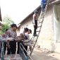 Personil polres Kediri membantu pasang genting warga terdampak angin kencang. ( Roy/Kediri)
