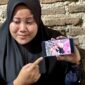 Putri salah satu korban Alm Sarip menunjukkan photo dirinya bersama sang ayah semasa hidup. ( Jatimnesia/Joko Nugroho).
