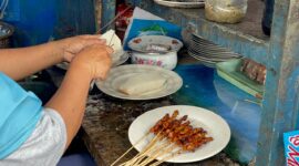 Salah Satu Penjaja Mamin Meracik Sate dan Lontong