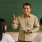 Seorang guru mengajar murid-muridnya di depan kelas (ilustrasi).