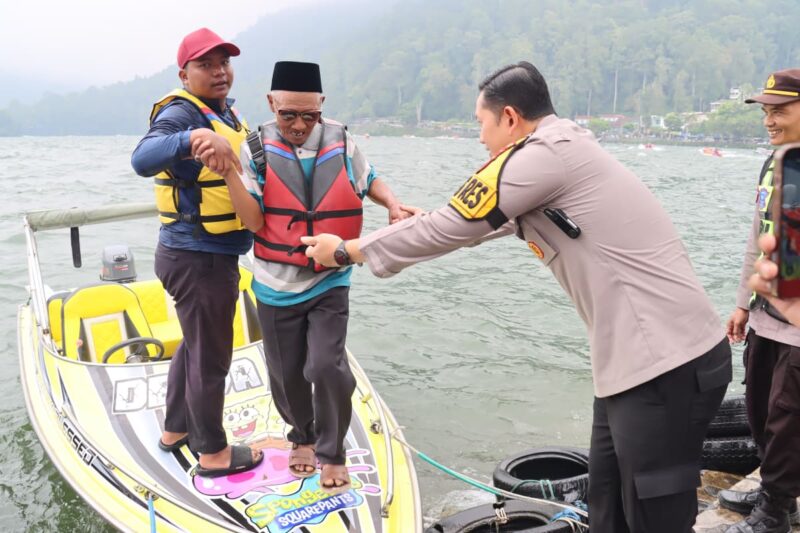 Kapolres Magetan Membantu Wisatawan Turun Dari Speadboat Di Telaga Sarangan.