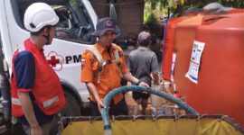 Petugas BPBD Ponorogo dibantu PMI Ponorogo berjibaku untuk mengirimkan air bersih ke wilayah kesulitan air bersih. 