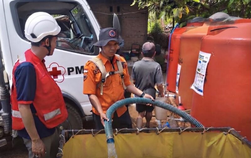 Petugas BPBD Ponorogo dibantu PMI Ponorogo berjibaku untuk mengirimkan air bersih ke wilayah kesulitan air bersih. 