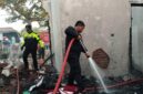 Petugas saat berupaya memadamkan kobaran api di rumah Dinas Puskesmas yang terbakar.