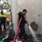 Petugas saat berupaya memadamkan kobaran api di rumah Dinas Puskesmas yang terbakar.