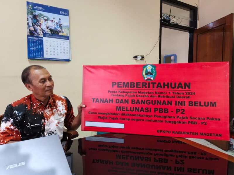 Kabid Penagihan, Evaluasi dan Pelaporan Badan Pengelolaan Keuangan dan Pendapatan Daerah BPKPD Magetan Sumarsono Tunjukan Papan Peringatan Yang Akan Dipasang Di Objek Pajak. 