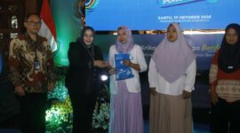 Plt Bupati Ponorogo Lisdyarita memberikan sertifikat atau izin Pangan Industri Rumah Tangga (P-IRT) kepada salah satu perwakilan UMKM didampingi Kepala OJK Kediri Ismirani Saputri.