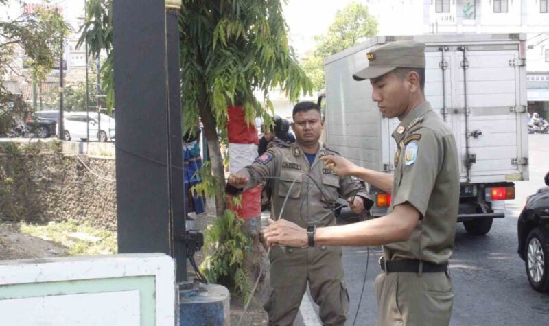 Tim Gabungan Pemkab Ponorogo potong kabel FO semrawut di Jalan Sultan Agung yang membahayakan.