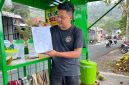 Fadzal Avista salah satu pedagang es kelapa muda yang ada di bibir Telaga Ngebel saat menunjukkan surat penertiban dari PJT I. 
