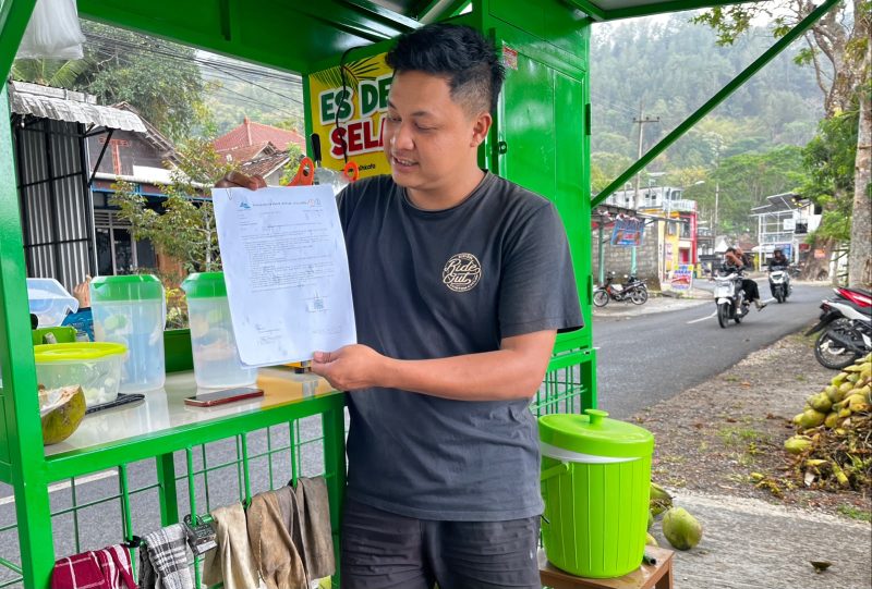 Fadzal Avista salah satu pedagang es kelapa muda yang ada di bibir Telaga Ngebel saat menunjukkan surat penertiban dari PJT I. 